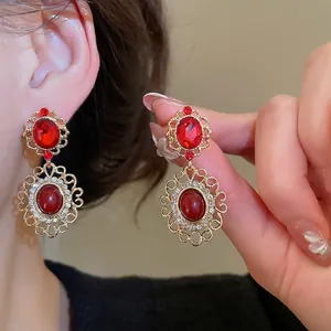 Vintage gold filigree drop earrings with ruby red stones and shimmering crystals