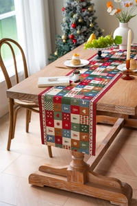 Detailed view of a Christmas table runner with reindeer and snowflake motifs on wood