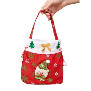 Red Christmas gift bag with 3D snowman, Xmas tree and bow, held by hand on white background