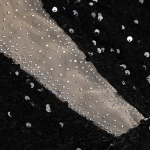 Detail of black sequins and silver rhinestones stitched on sheer mesh fabric