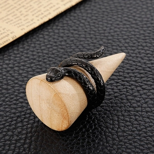 Detailed view of a black cobra snake ring with scale texture on a wooden stand