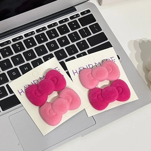 Close-up of pink and magenta flocked bow hair clips set on a display card