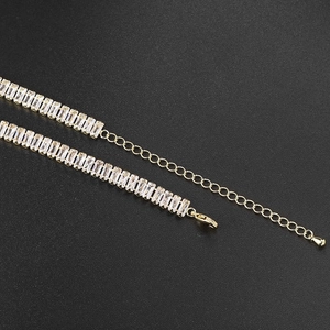 Vue macro du collier tennis doré avec zircons rectangulaires et fermoir mousqueton