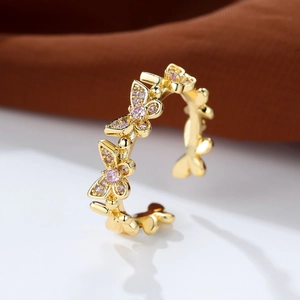 Detailed macro shot of a gold butterfly ring with sparkling pink inlaid gemstones
