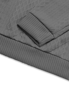 Detail view of dark grey jacquard knit fabric showing ribbed cuffs and textured material