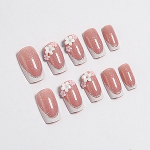 Faux ongles carrés courts avec bouts French blancs et fleurs 3D de couleur rose nude