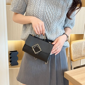 Elegante bolso de mano negro con relieve, cierre dorado y correa de cadena metálica