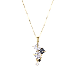 Collana geometrica dorata con pietre di zircone bianche e nere su sfondo bianco