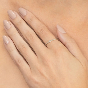Detailed view of minimalist gold-plated eternity ring with pavé diamonds on finger
