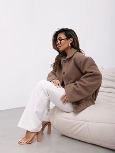 Gros plan sur la texture de la veste en laine marron avec boutons et surface moelleuse