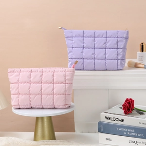 Detail of pink and purple quilted cosmetic bags on a white fireplace with decor