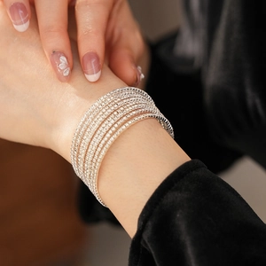 Detailed close-up of a silver multi-layer rhinestone stretch bracelet on a wrist