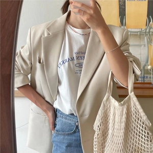Chic beige blazer styled with graphic tee, jeans and a woven cotton mesh bag