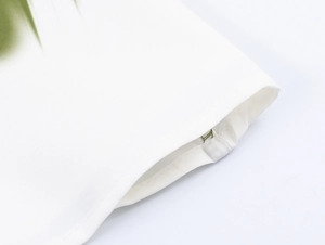 Detailed macro view of white dress fabric with green print and precise stitching