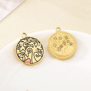 Macro shot of gold Tree of Life pendants with rhinestones and pink heart detail