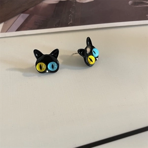 Close-up of black cat stud earrings with asymmetric blue and yellow eyes