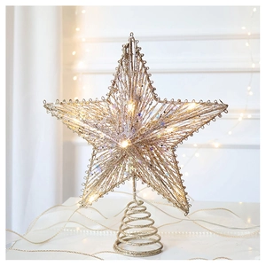 Detail of gold star tree topper with warm LED lights and glitter finish texture