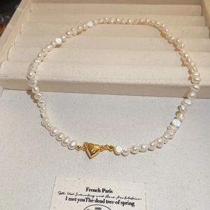 Macro detail of Baroque freshwater pearl necklace with 18K gold heart magnetic clasp