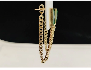 Detail view of gold titanium steel earrings with green crystal and hanging chain