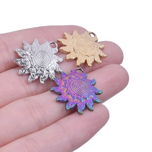 Macro detail of sun-shaped stainless steel charms in gold silver and rainbow finishes