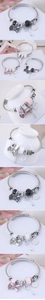 Detailed view of Tree of Life bangles with bow and key charms in silver finish