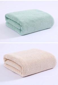 Detail of coral fleece towels with waffle texture in soft green and beige colors
