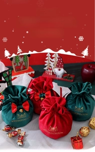 Detail of red and green velvet Christmas gift bags with gold bells and bowknots