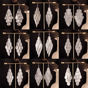 Nine styles of vintage silver leaf earrings on stands with elegant black background