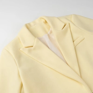 Elegant light yellow wool blend long coat featuring textured fabric and classic lapel