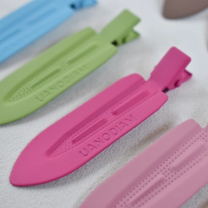 Macro shot of colorful matte textured hair clips featuring UANODIAN engraved logo detail