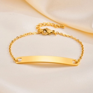 Polished gold stainless steel ID bracelet for women with curved bar on velvet background