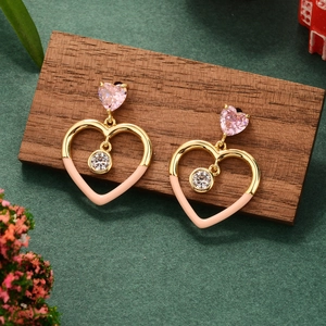 Detail view of heart shaped zircon earrings with gold frame on a rustic wood stand