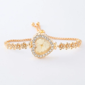 Close-up of golden heart-shaped watch dial with sparkling rhinestone floral accents