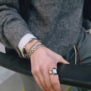 Polished stainless steel bracelet set with chain and ring on model wearing grey knitwear