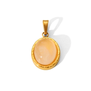 Macro shot of gold stainless steel oval pendant with a natural light orange gemstone