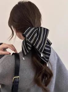 Détail d'un chouchou à rayures noires et blanches avec pendentifs en perles élégants