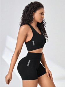 Side view of seamless black gym set with white vertical GYMWEAR printing on side