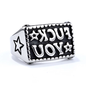 Macro shot of silver stainless steel ring with star engraving and dark metal contrast