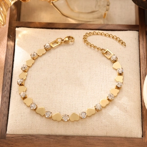 Adjustable golden heart bracelet with sparkling zircon crystals on a luxury display pad