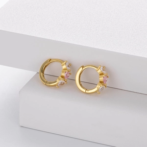 Detailed shot of golden 925 silver hoop earrings with pink and white heart-shaped zircon