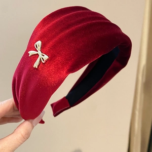 Close-up of vintage red velvet headband featuring a delicate gold bow metal accessory