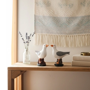 Mediterranean resin seagull sculptures on wooden table with elegant home decor