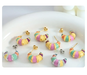 Detailed macro of vintage colorful striped enamel hoop earrings in gold and silver finish