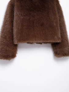 Close-up of deep brown faux fur texture and stitching details on the hem and sleeve cuff