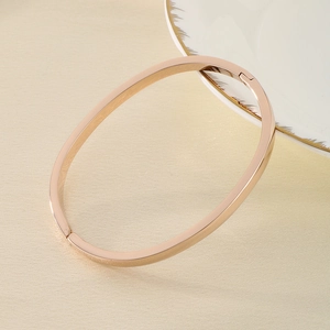 Detail of rose gold stainless steel oval bangle with polished finish and secure clasp