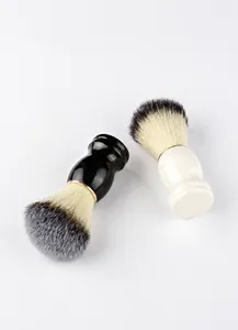 Detail of manual shaving brushes with ergonomic black and white handles and gold rings