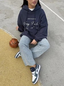 Λεπτομέρεια από μπλε σκούρο oversized φούτερ με τύπωμα και τσάντα μπάσκετ σε street style