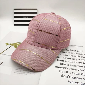 Detailed view of pink baseball cap with horizontal gold sequin stripes and fabric texture