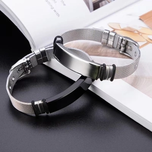 Silver and black Milanese mesh bracelets with polished steel plates on a magazine