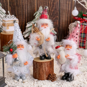 Three decorative Santa Claus figurines in checkered and sequined hats on snow scenery